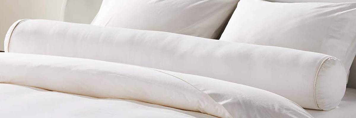 36-inch bolster pillow supports the other pillows on a bed