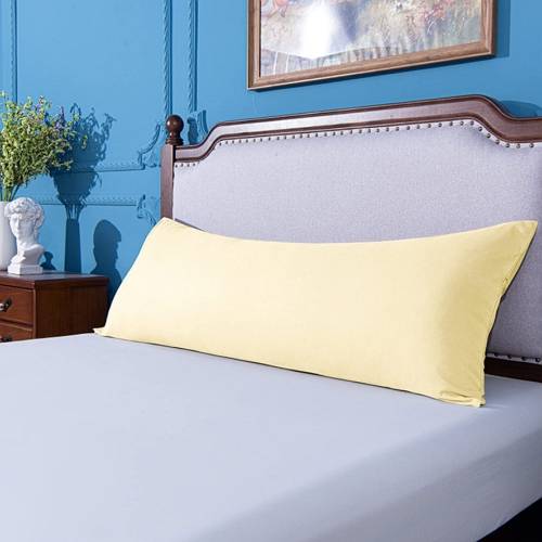 yellow bolster body pillow on a gray bed