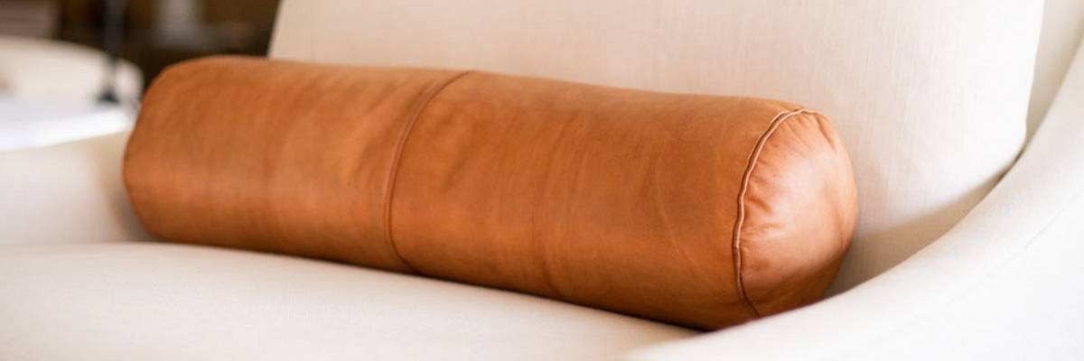 leather bolster pillow on a light sofa