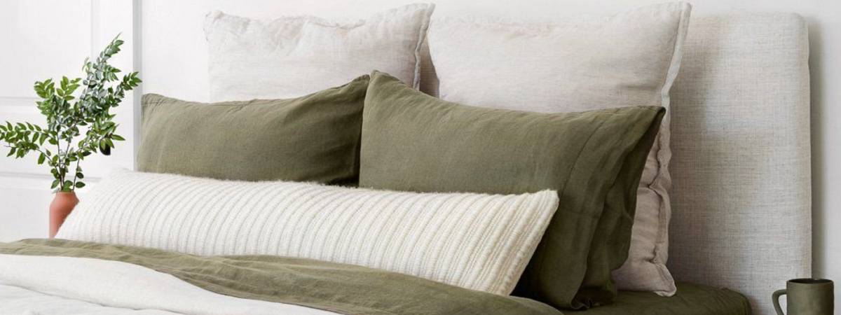 white bolster pillow in interior with olive accents