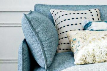 bolster pillows on a blue sofa matching the other decorative elements