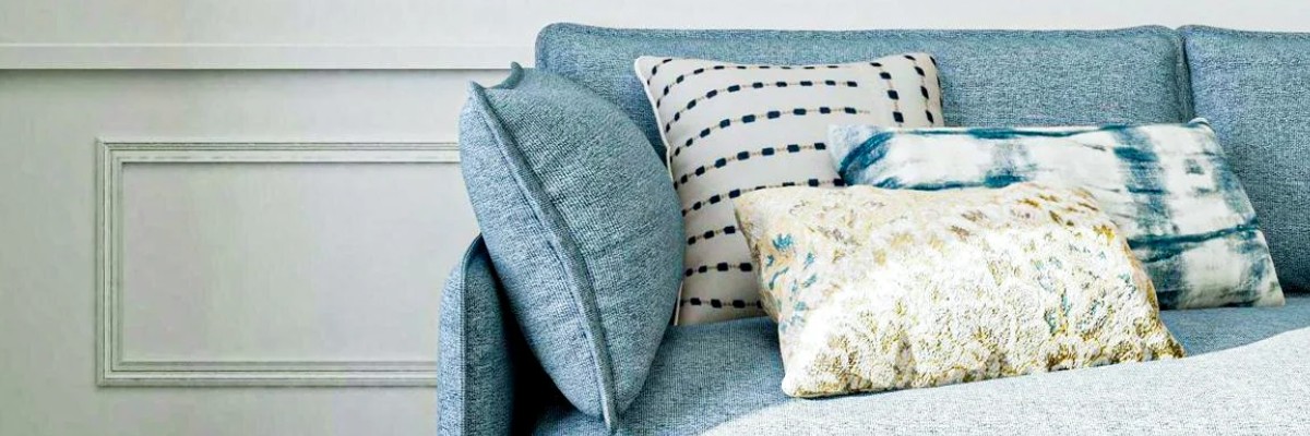 bolster pillows on a blue sofa matching the other decorative elements