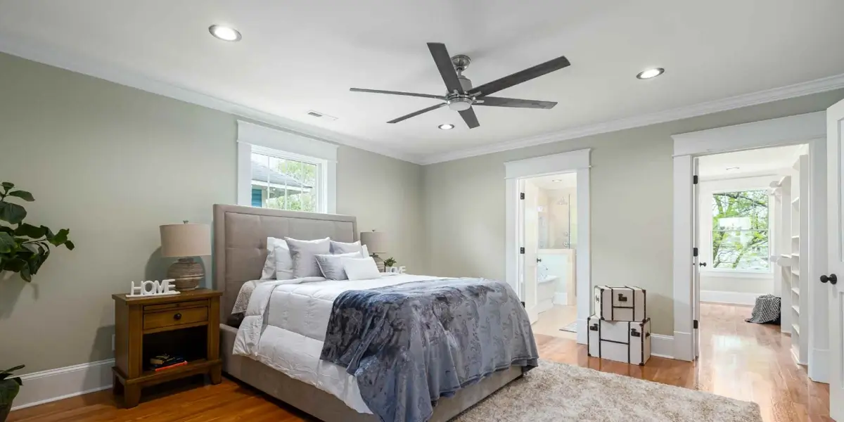 spaceous bedroom with a ceiling fan installed
